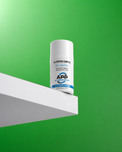 A white bottle of APP Peptide Complex All Flavor Cream with a blue and white label, displayed on a white geometric platform against a vibrant green background.