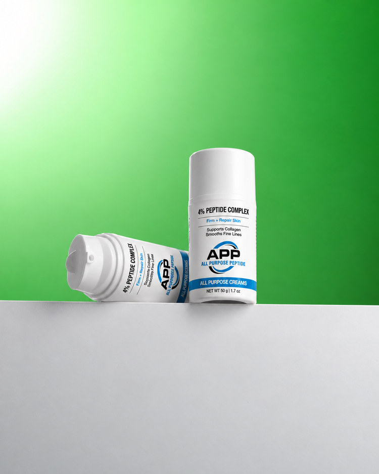 Two white bottles of APP All Purpose Cream with blue and black text, displayed on a white surface against a green gradient background.